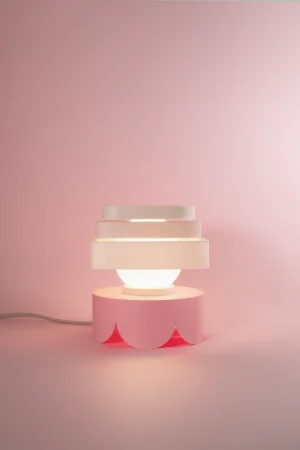 Fotografía de lámpara de sobremesa Petit Four Merengue color blanco estilo diseño contemporáneo sobre fondo rosa