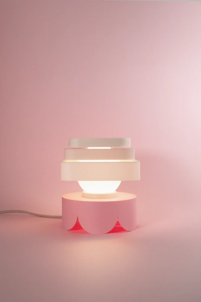 Fotografía de lámpara de sobremesa Petit Four Merengue color blanco estilo diseño contemporáneo sobre fondo rosa