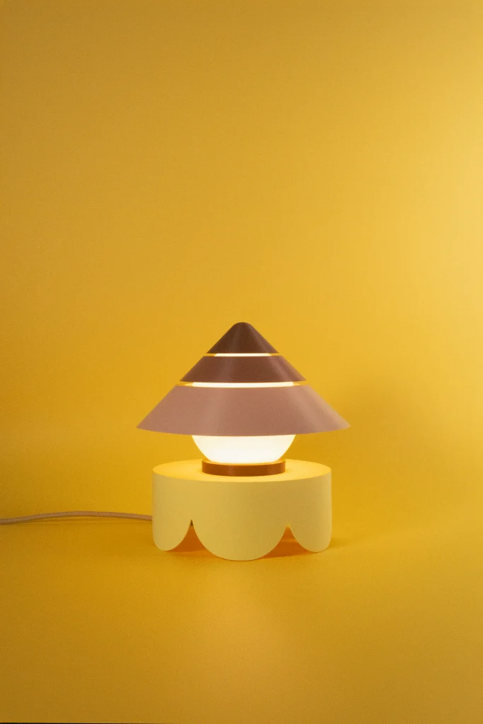 Fotografía de lámpara de sobremesa Petit Four Bombón color marrón estilo diseño contemporáneo sobre fondo amarillo